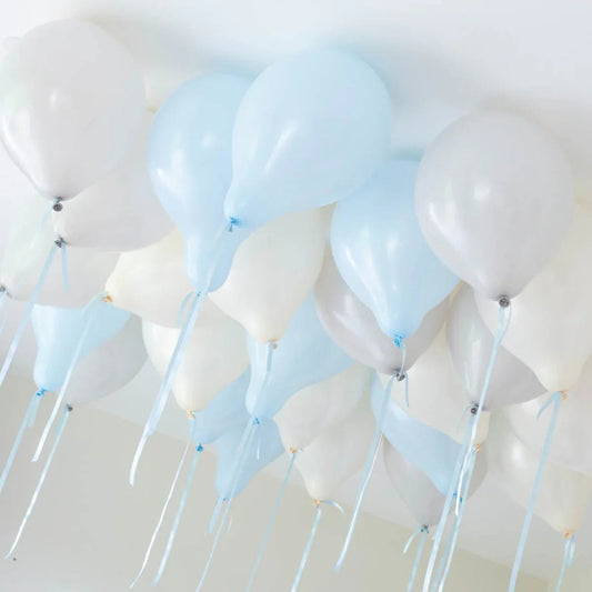 Cluster of helium balloons in soft blue, white, and cream colors attached to a ceiling