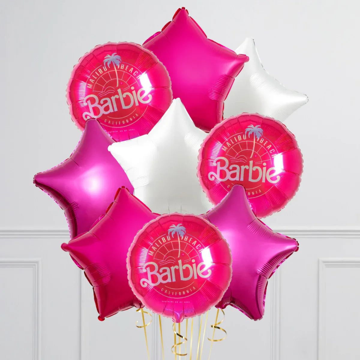 Pink and white star-shaped and round Malibu Barbie foil balloons against white wall