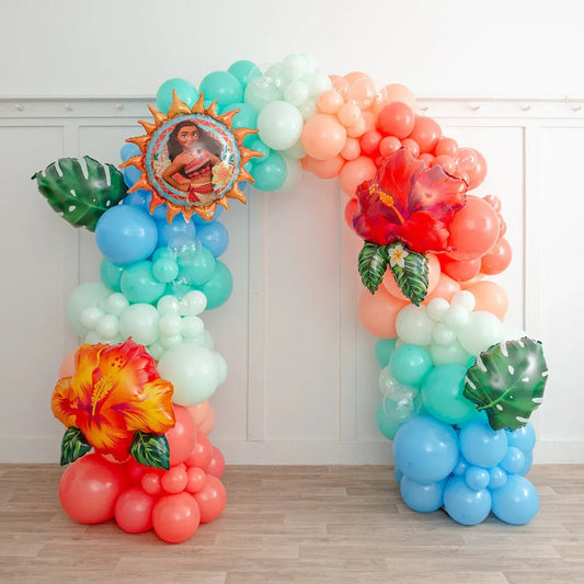 Colorful Moana-themed balloon arch with tropical flower and leaf foil balloons in a room