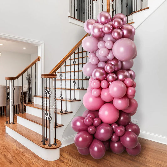 Pink and mauve balloon pillar decoration next to wooden staircase in modern home interior