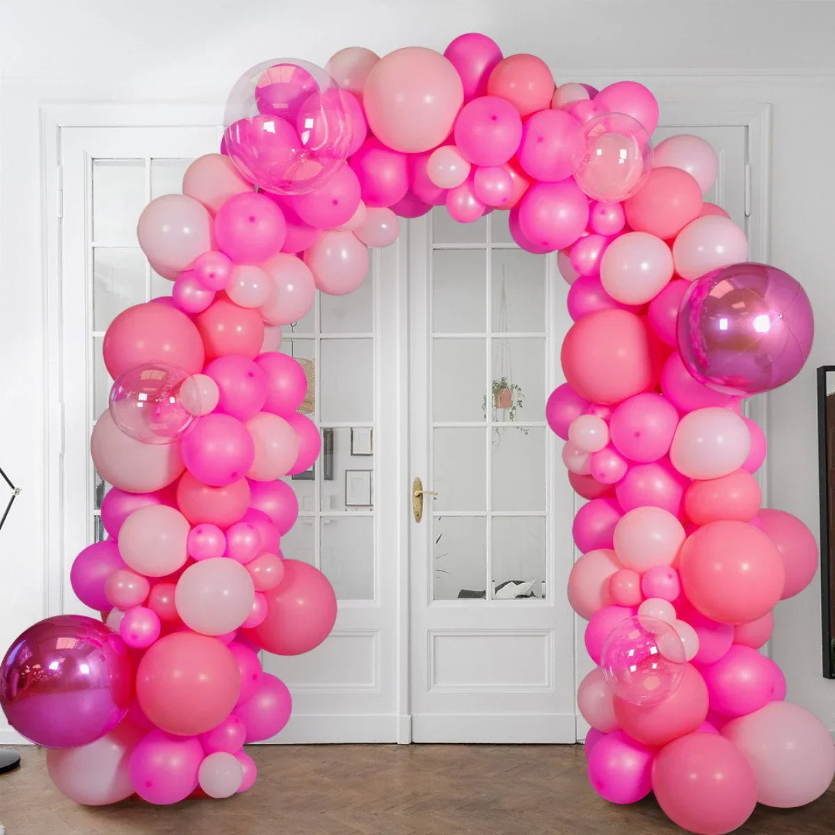 Neon pink and blush balloon arch decoration in front of white double doors indoor party setup