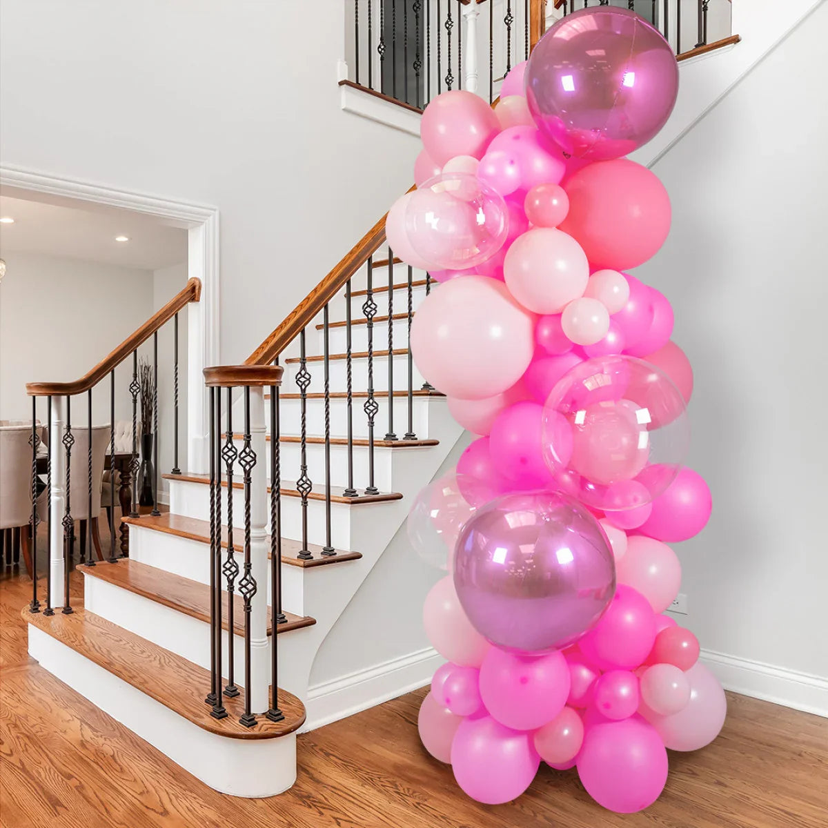 Pink balloon pillar decoration with various shades of pink balloons by indoor staircase