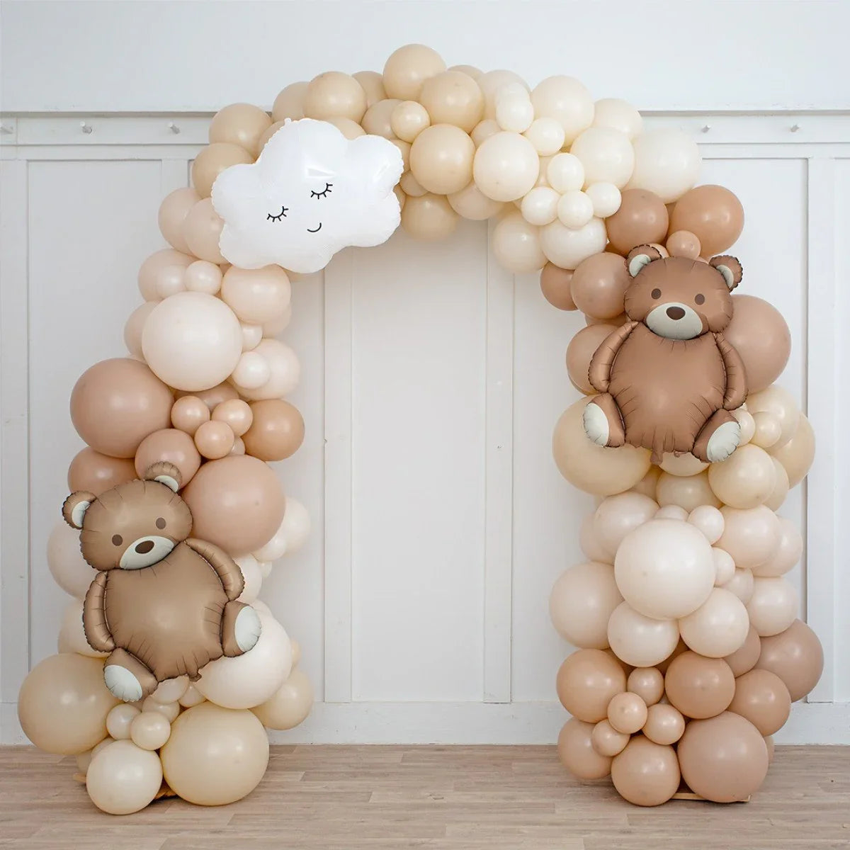 Neutral beige balloon arch with teddy bear and smiling cloud balloons for party decoration