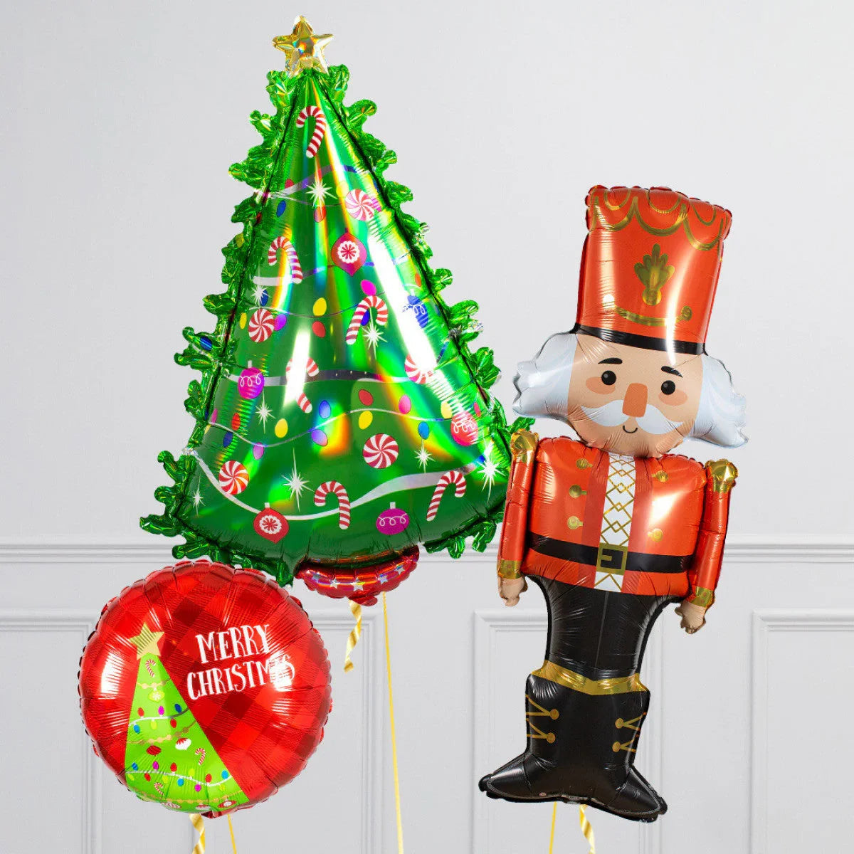Christmas balloons with a green decorated tree, red Merry Christmas circle, and nutcracker soldier on white background