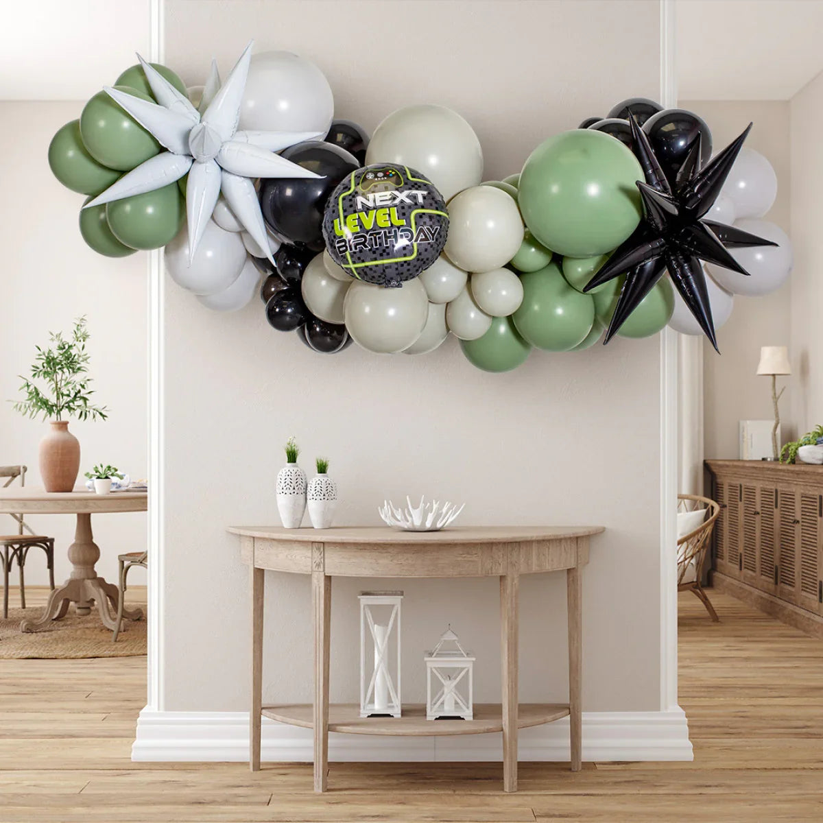 Next Level Birthday balloon garland in green, black, white with star-shaped balloons over wooden table