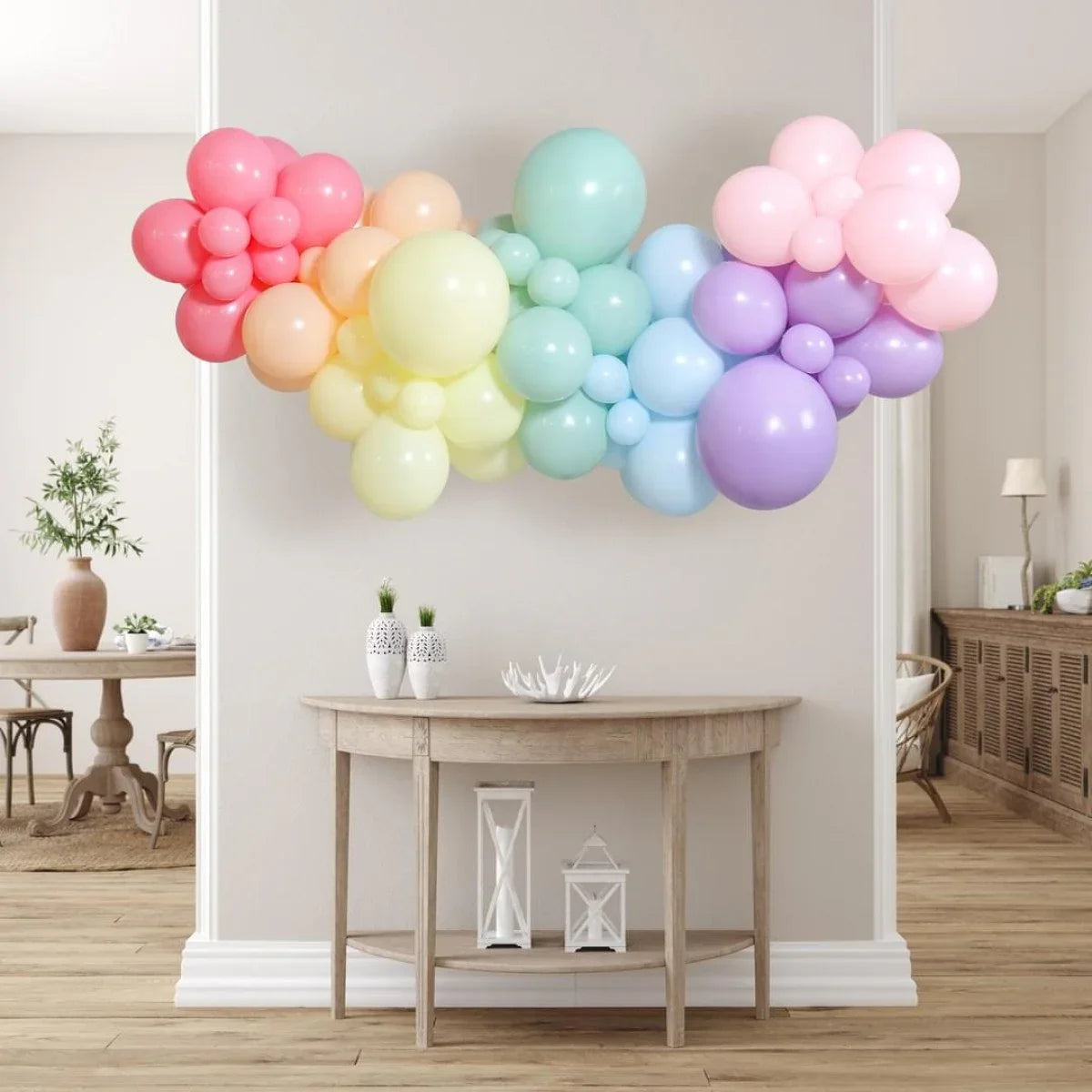 Pastel rainbow balloon garland hanging above wooden console table in stylish modern room
