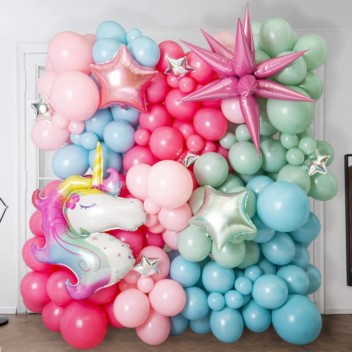 Colorful pastel balloon wall with unicorn balloon and star-shaped balloons for party decoration