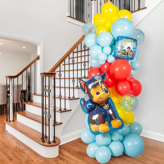 Indoor colorful balloon pillar with blue, red, yellow balloons and Paw Patrol birthday foil balloons by staircase