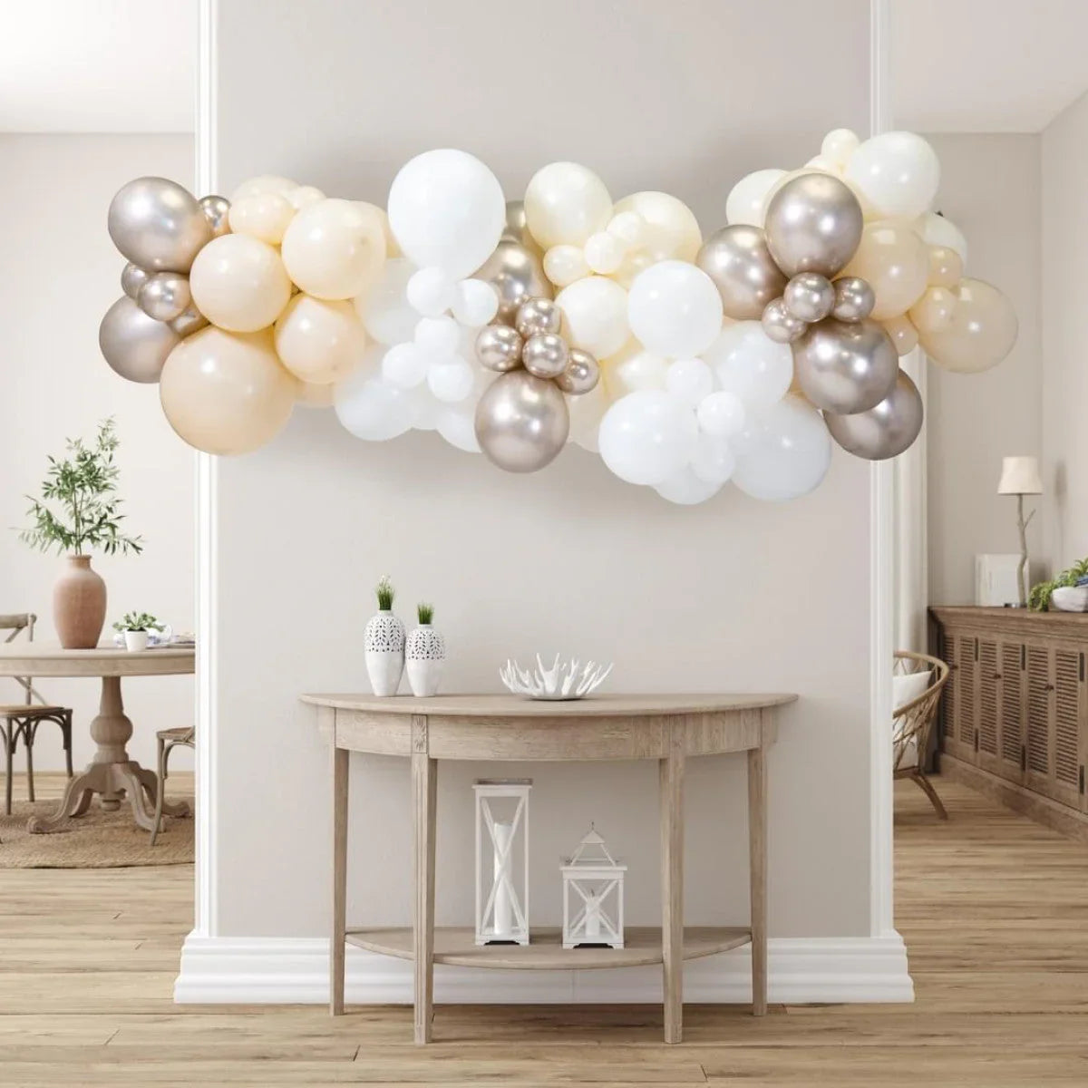 Pearl tone balloon garland with white, cream, and metallic silver balloons over wooden console table in modern room