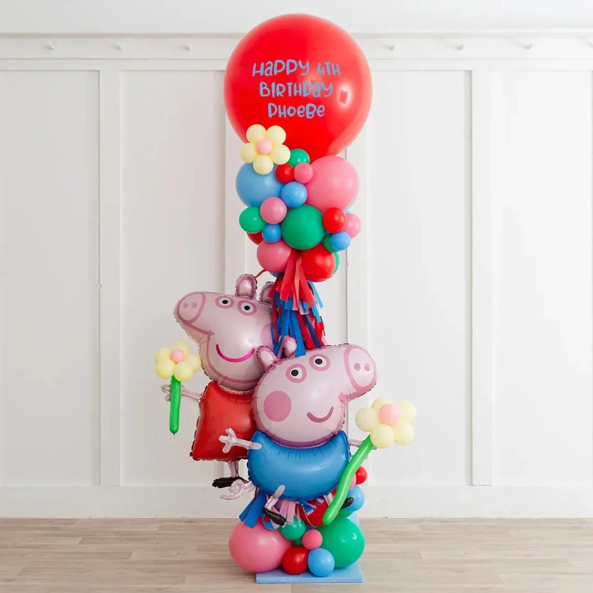 Peppa Pig themed balloon pillar with red birthday balloon and colorful smaller balloons indoors