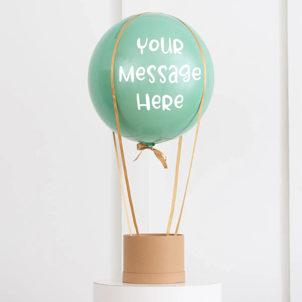 Personalized eucalyptus green hot air balloon decoration with custom message, gold ribbons, and cardboard basket