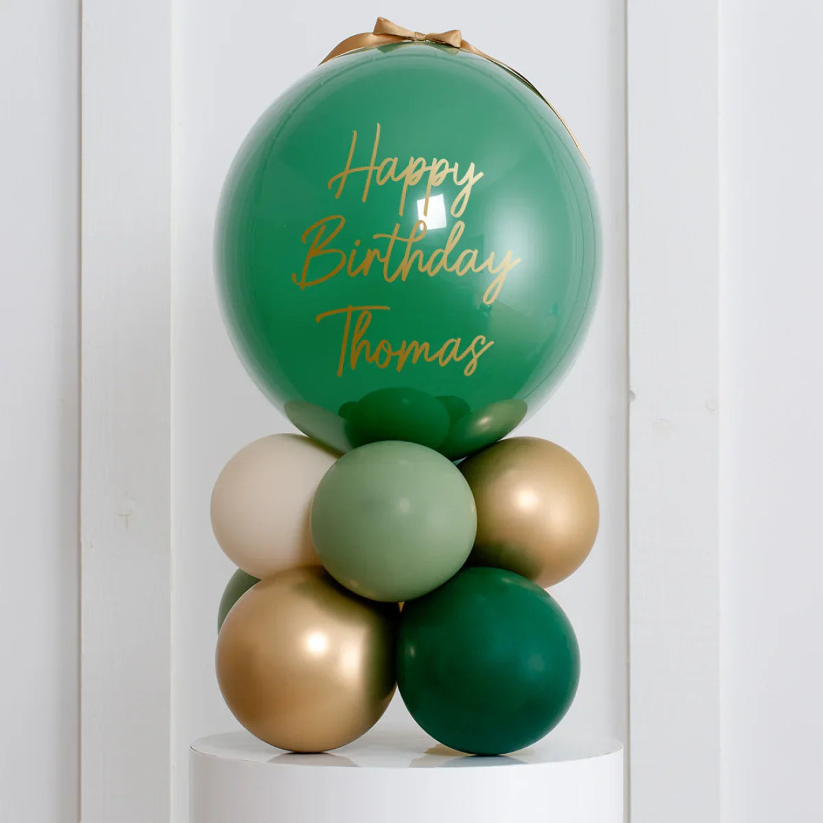 Personalized forest green birthday bubble balloon stack with gold, cream, and green balloons