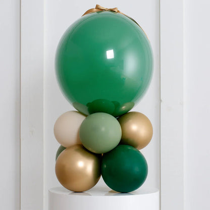 Forest green and gold air-filled balloon stack decoration on white pedestal
