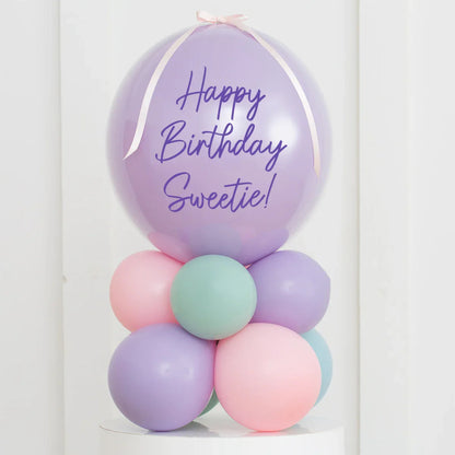 Personalised pastel balloon stack with 'Happy Birthday Sweetie!' message on lavender air-filled bubble balloon