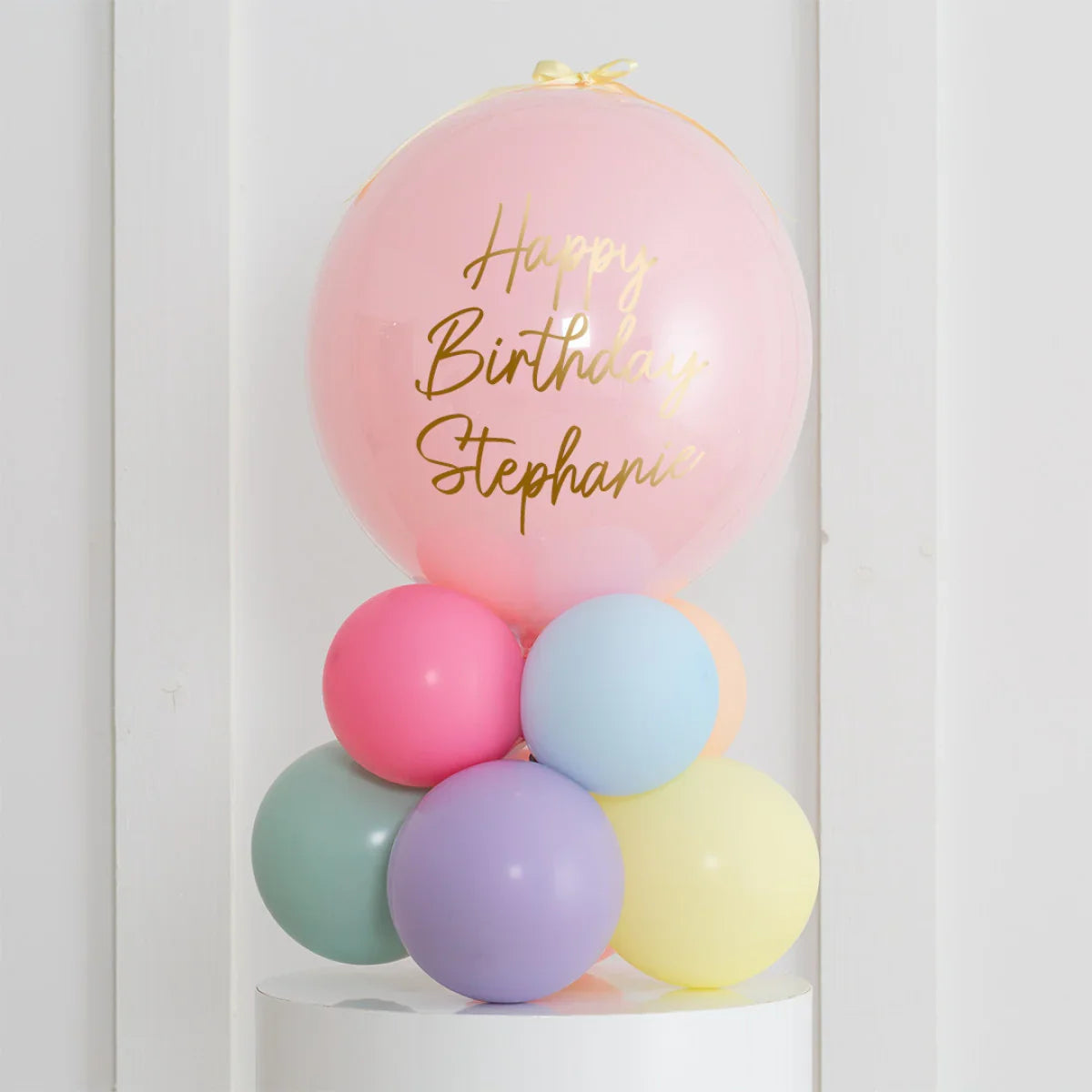Personalised pastel balloon stack with pink air-filled bubble reading Happy Birthday Stephanie