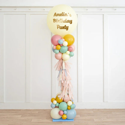 Personalised pastel balloon pillar with tassels and 'Amelia's Birthday Party' text for celebration decor
