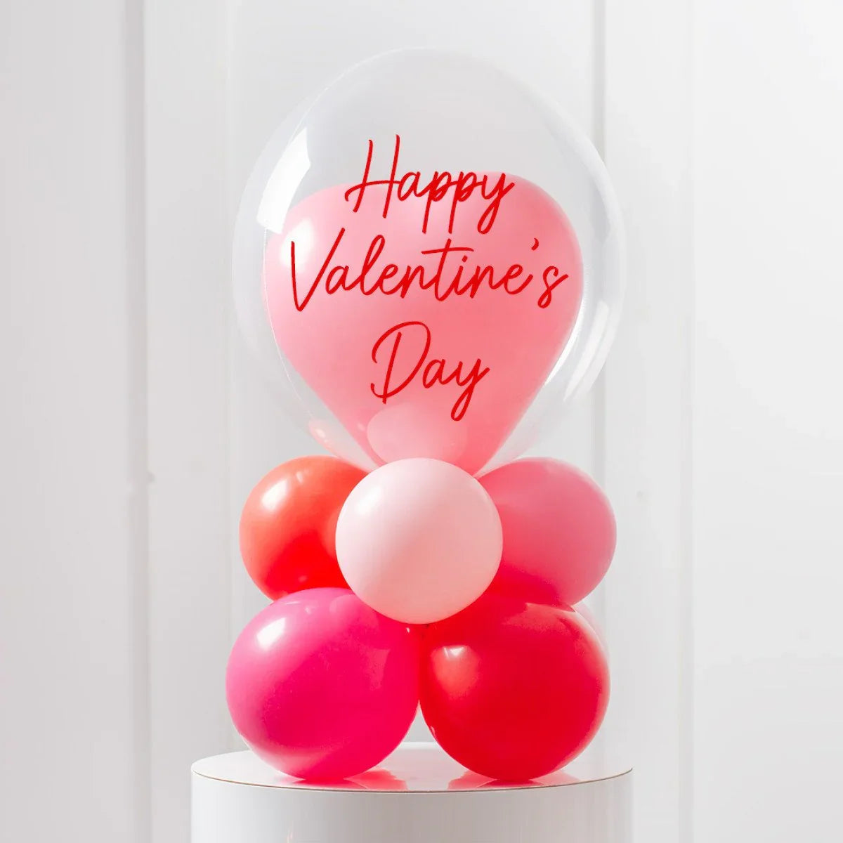 Valentine's Day balloon arrangement with pink and red balloons inside a clear bubble balloon