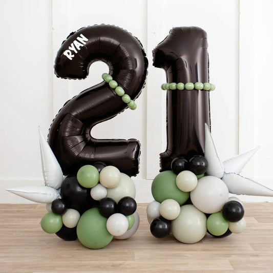 Black number 21 birthday balloons with green, white, and black balloon cluster base and silver spikes
