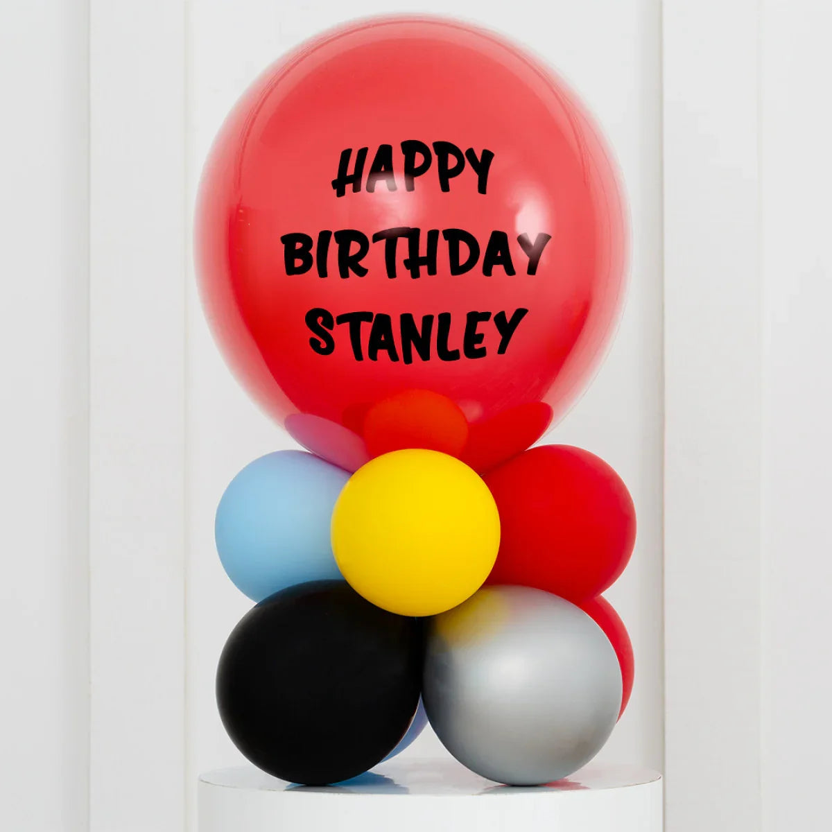 Colorful birthday balloon arrangement with a large red balloon saying Happy Birthday Stanley