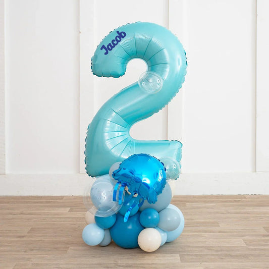 Personalized light blue number 2 balloon with name Jacob on top, surrounded by blue and white balloon cluster