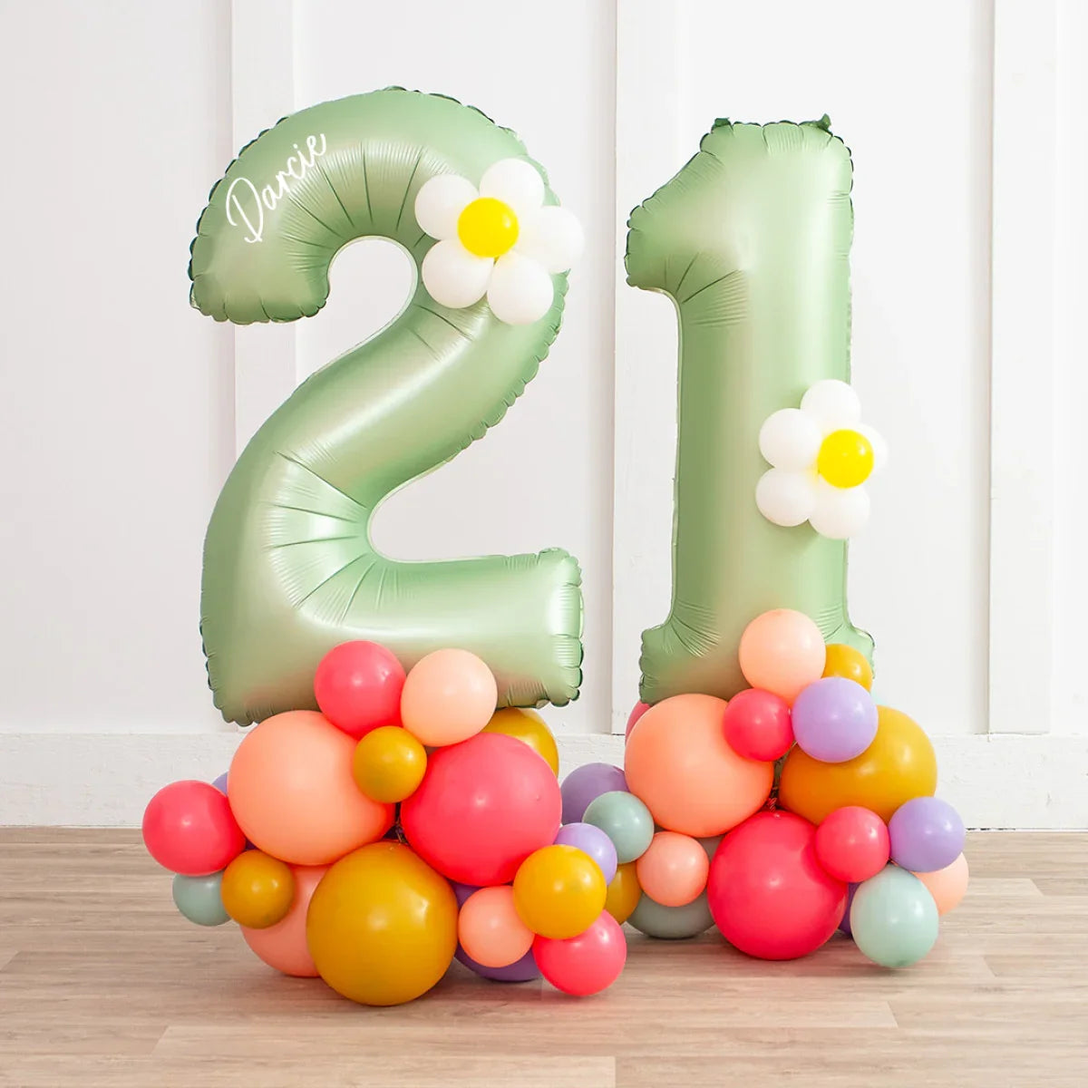 Green number 21 foil balloons decorated with white daisy balloons on multicolored balloon bases