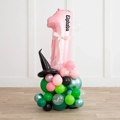 Personalized pink number 1 balloon with Elphaba text and witch hat balloon stack with green, pink, and black balloons