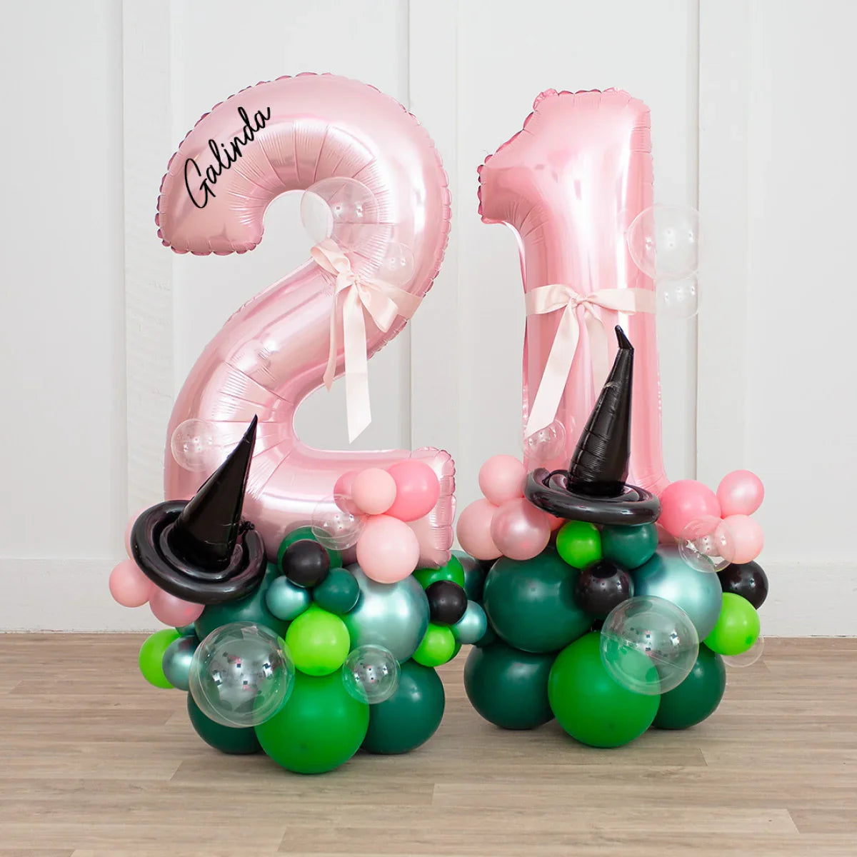Pink foil number 21 balloons with pink ribbons on green and black balloon bases with black witch hats