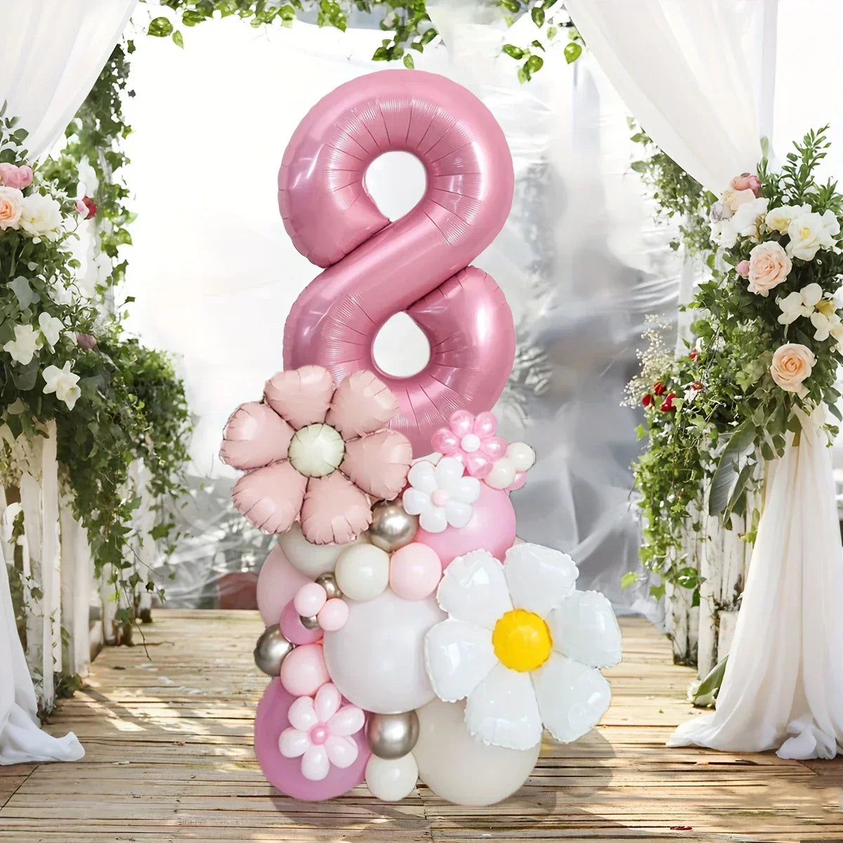 Pink number 8 balloon centerpiece with pastel floral balloons on wooden deck with white curtains and greenery