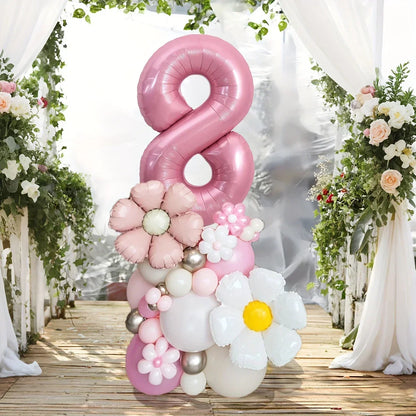 Pink number 8 balloon centerpiece with pastel floral balloons on wooden deck with white curtains and greenery