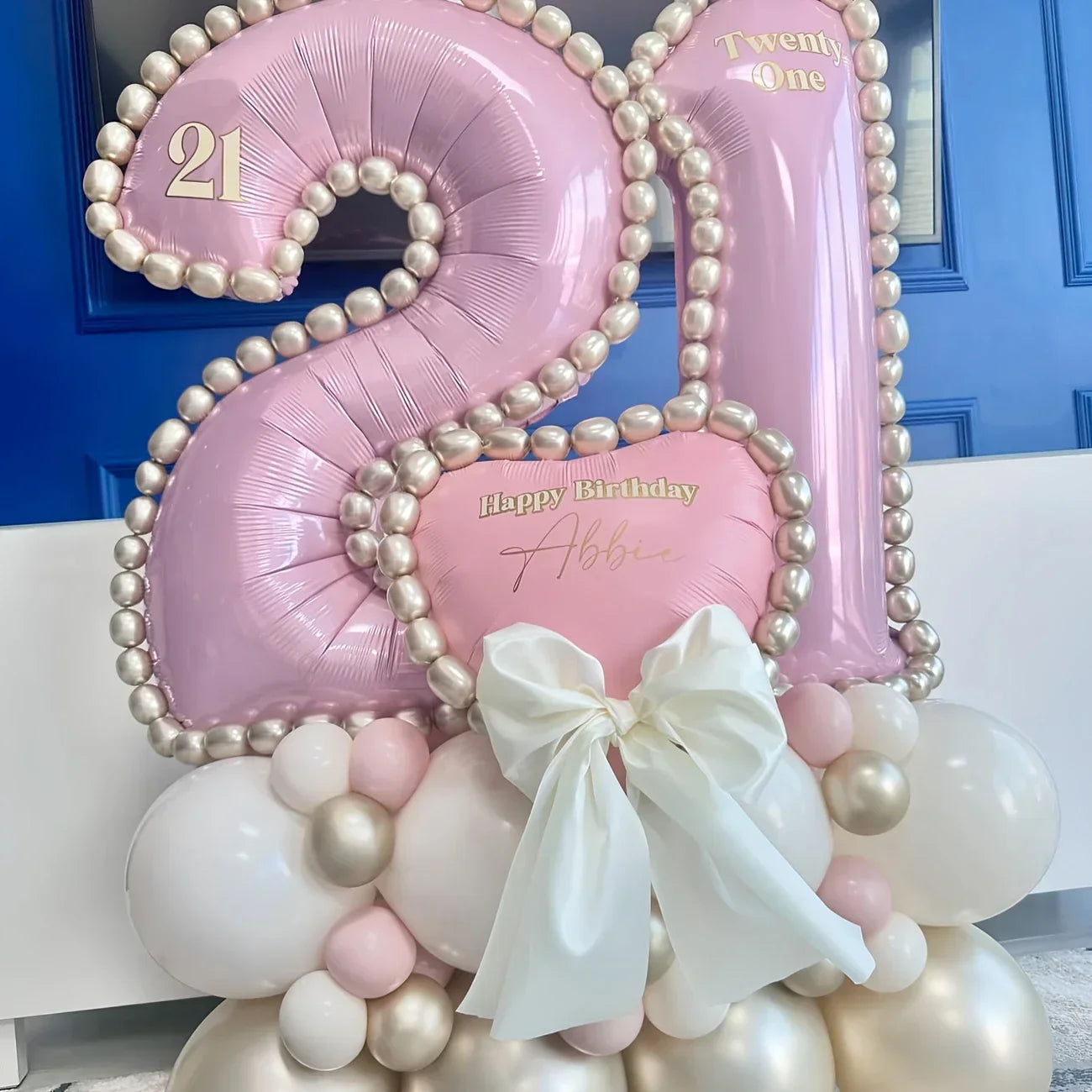 Pink and white metallic 21 birthday balloon arrangement with pearl accents and large white bow