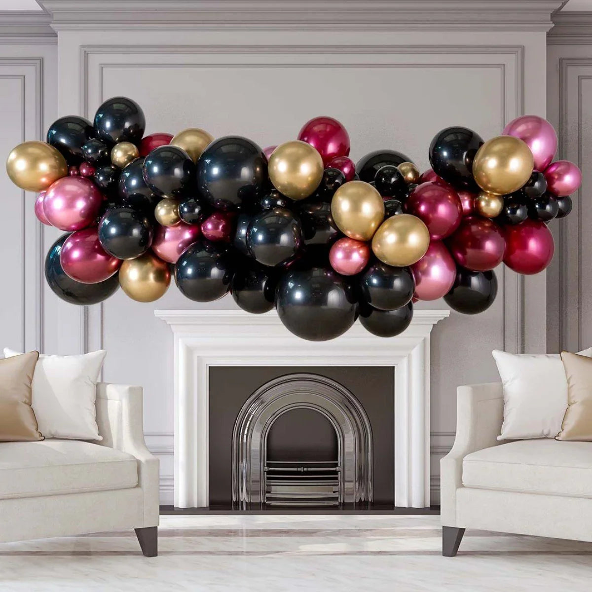 Pomegranate glitz balloon garland in black, gold, and pink above white fireplace in stylish living room