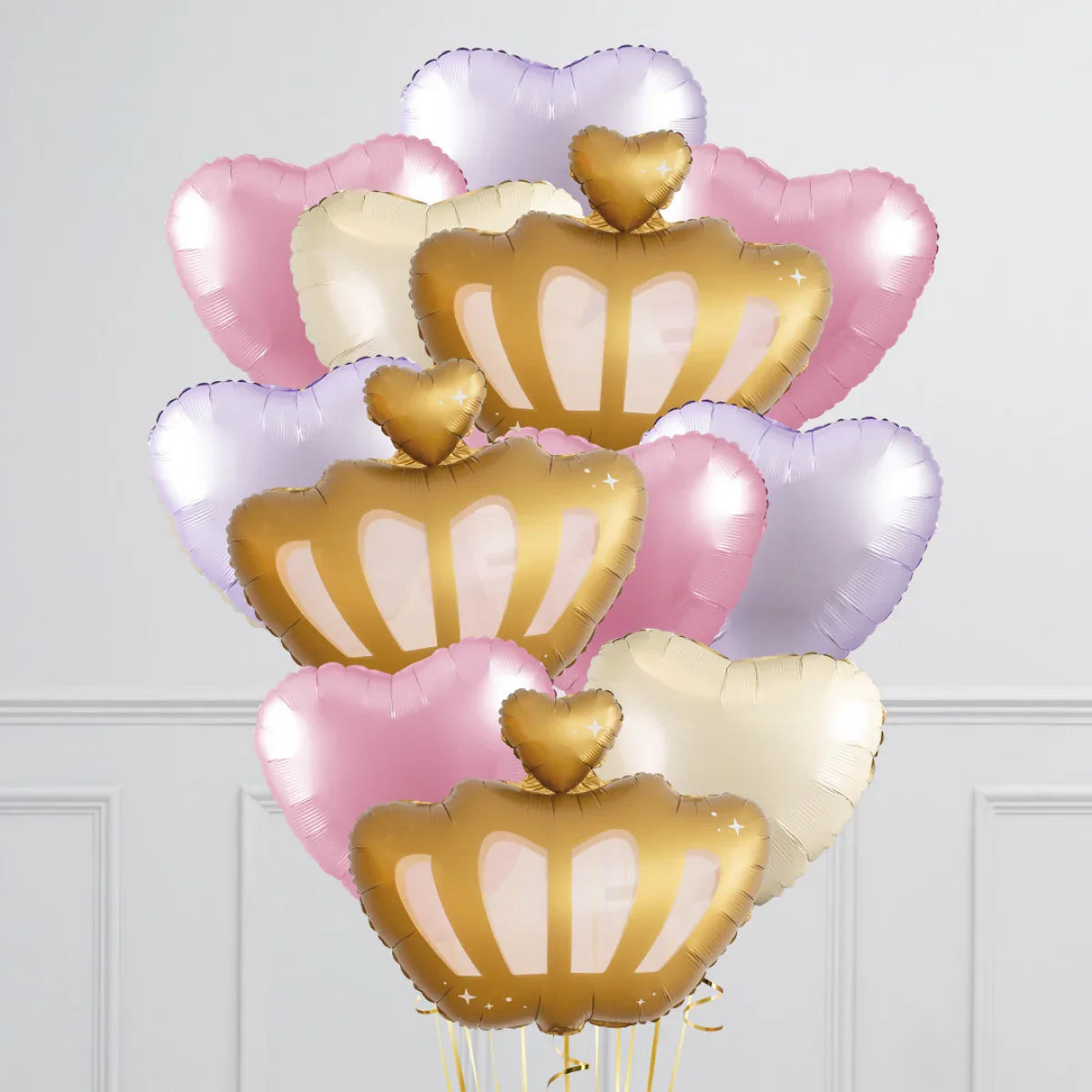 Bunch of gold crown and pastel heart-shaped foil balloons in pink, purple, and cream colors