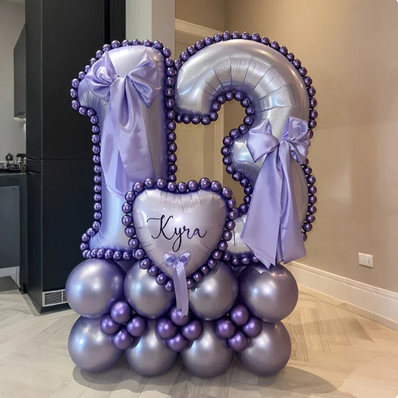 Purple and silver balloon arrangement shaped as number 13 with purple bows and heart balloon labeled Kyra