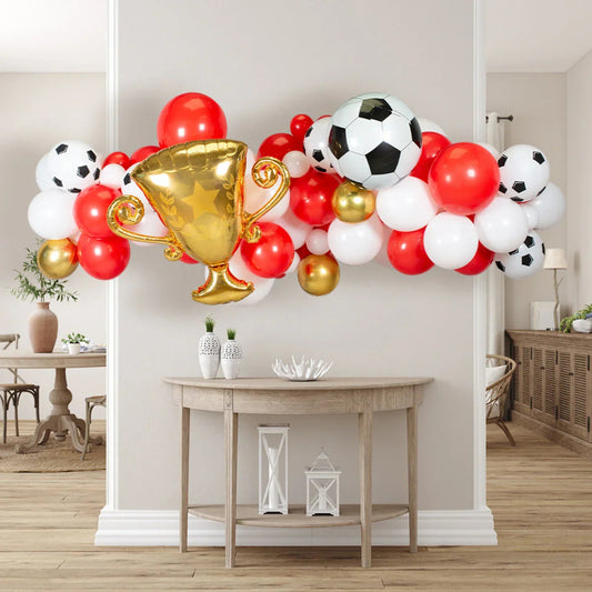 Red, white, and gold soccer-themed balloon garland with gold trophy and soccer ball balloons