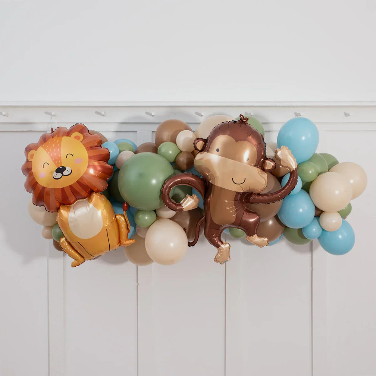 Inflated balloon garland with cute lion and monkey foil balloons in pastel blue, green, beige, and brown