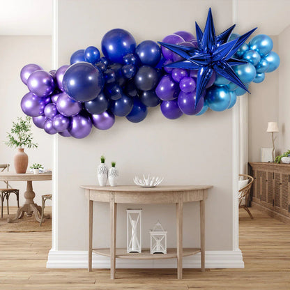 Vibrant balloon garland in shades of purple, blue, and teal with a large blue star balloon in a modern living room