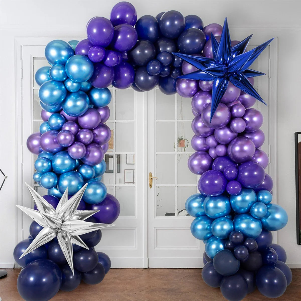 Metallic blue and purple balloon arch with star-shaped balloons decorating indoor doorway