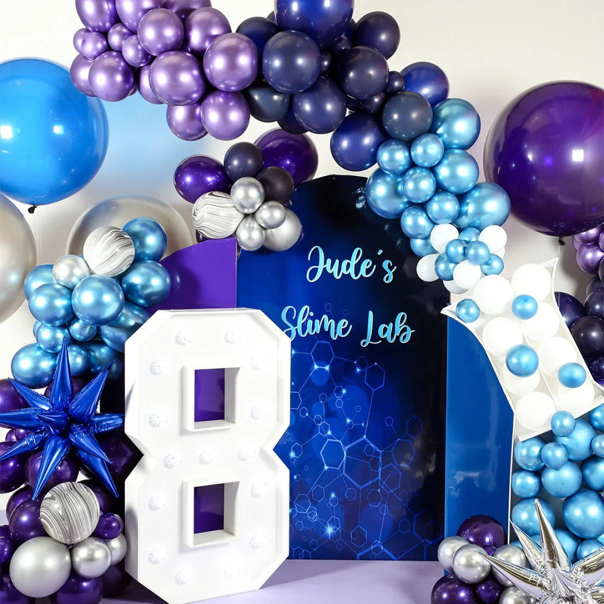 Science-themed birthday party decoration with purple, blue, silver balloons and large white number 8