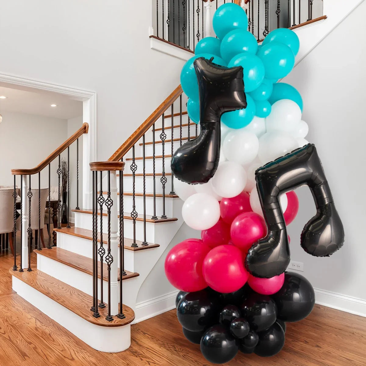 Colorful balloon pillar with teal, white, red, and black balloons including black musical note foils near staircase