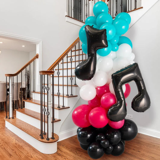 Colorful balloon pillar with teal, white, red, and black balloons including black musical note foils near staircase