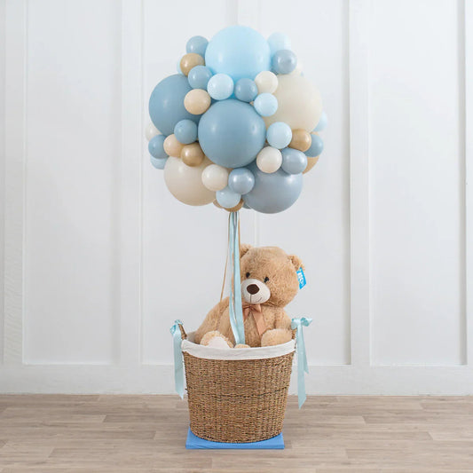 Soft blue, cream, and beige balloon cluster with teddy bear in wicker basket hot air balloon decoration