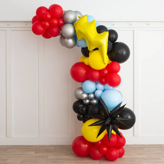 Asymmetric balloon arch with red, black, yellow, blue, silver balloons and star and lightning shapes