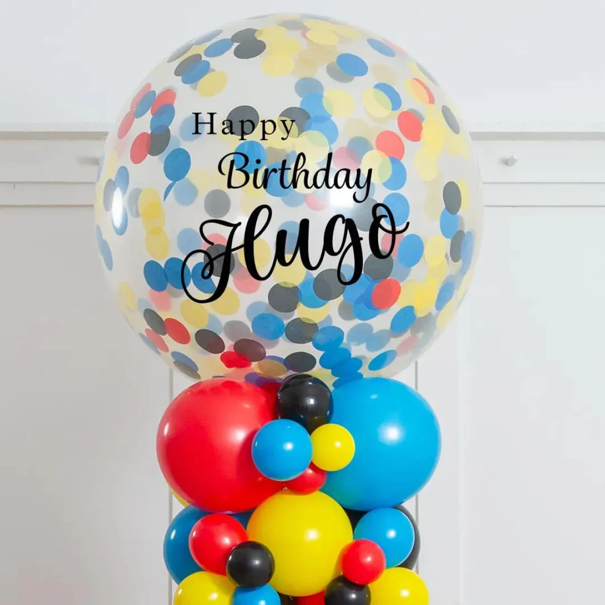 Colorful birthday balloon bouquet with confetti balloon and text Happy Birthday Hugo