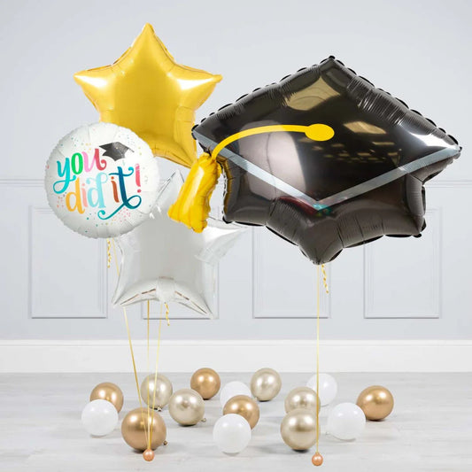 Graduation balloon bouquet with black cap balloon, gold and silver stars, and white round balloon saying You did it