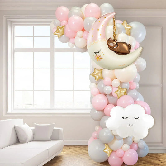 Baby pink and gray balloon arch with gold stars, moon and cloud balloons in modern living room