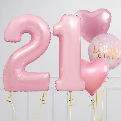 Pink foil balloons shaped 2 and 1 with heart balloons and Birthday Girl balloon in a white room