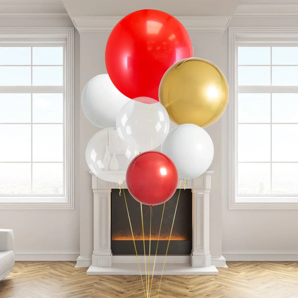 Cluster of red, gold, white, and clear balloons in a bright living room with a fireplace and large windows