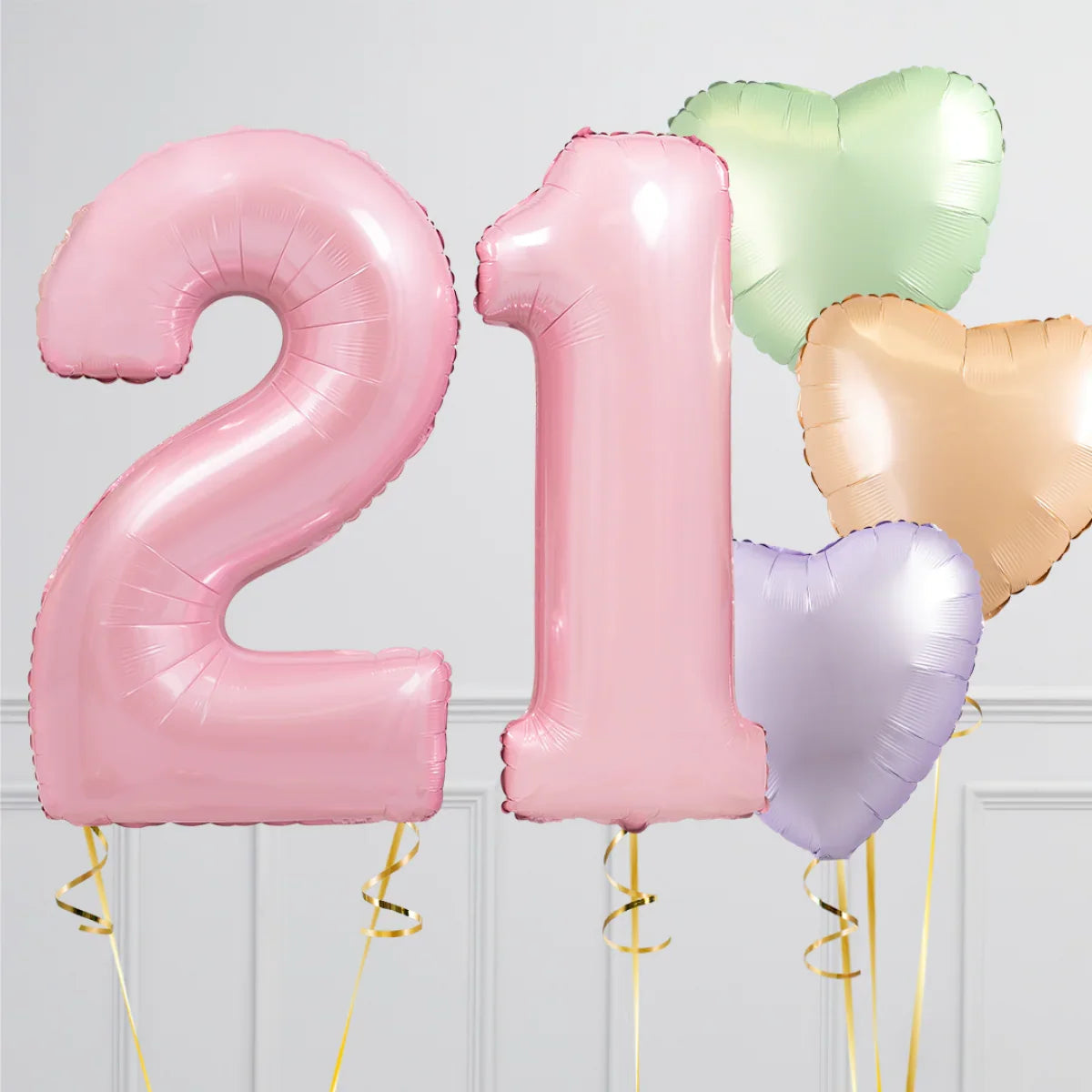 Pink number 21 balloons with green, gold, and purple heart-shaped balloons on a white background
