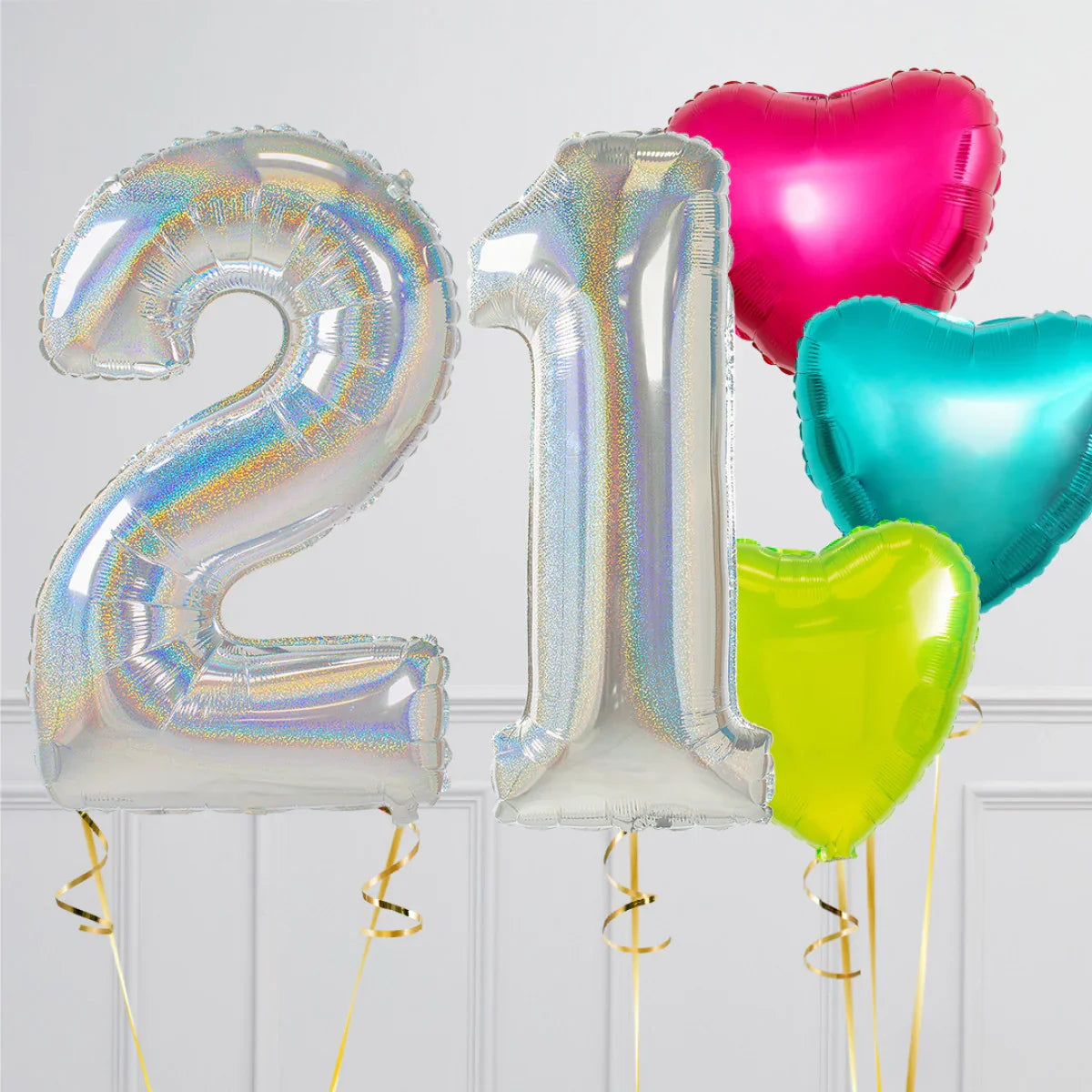 Silver holographic number 21 balloons with pink, blue, and yellow heart-shaped foil balloons on white background