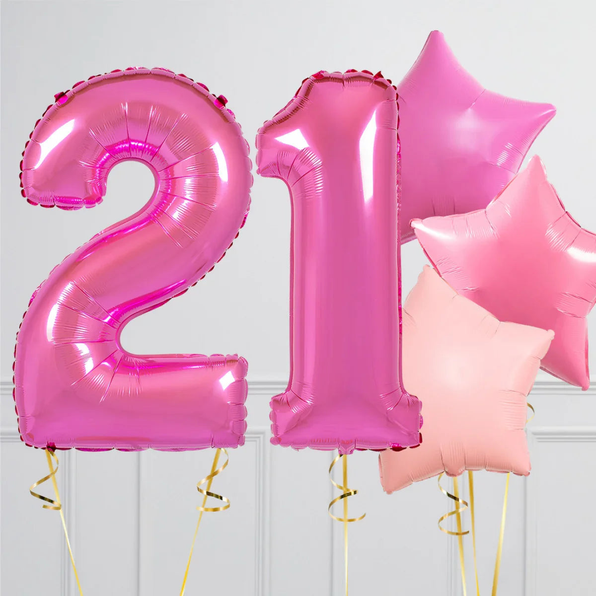 Pink foil balloons shaped as number 21 and star-shaped balloons for 21st birthday celebration